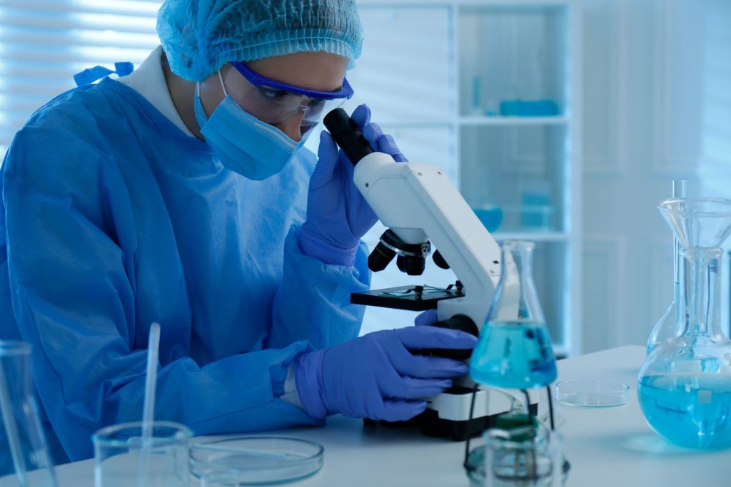 Pathologist working with microscope in laboratory.